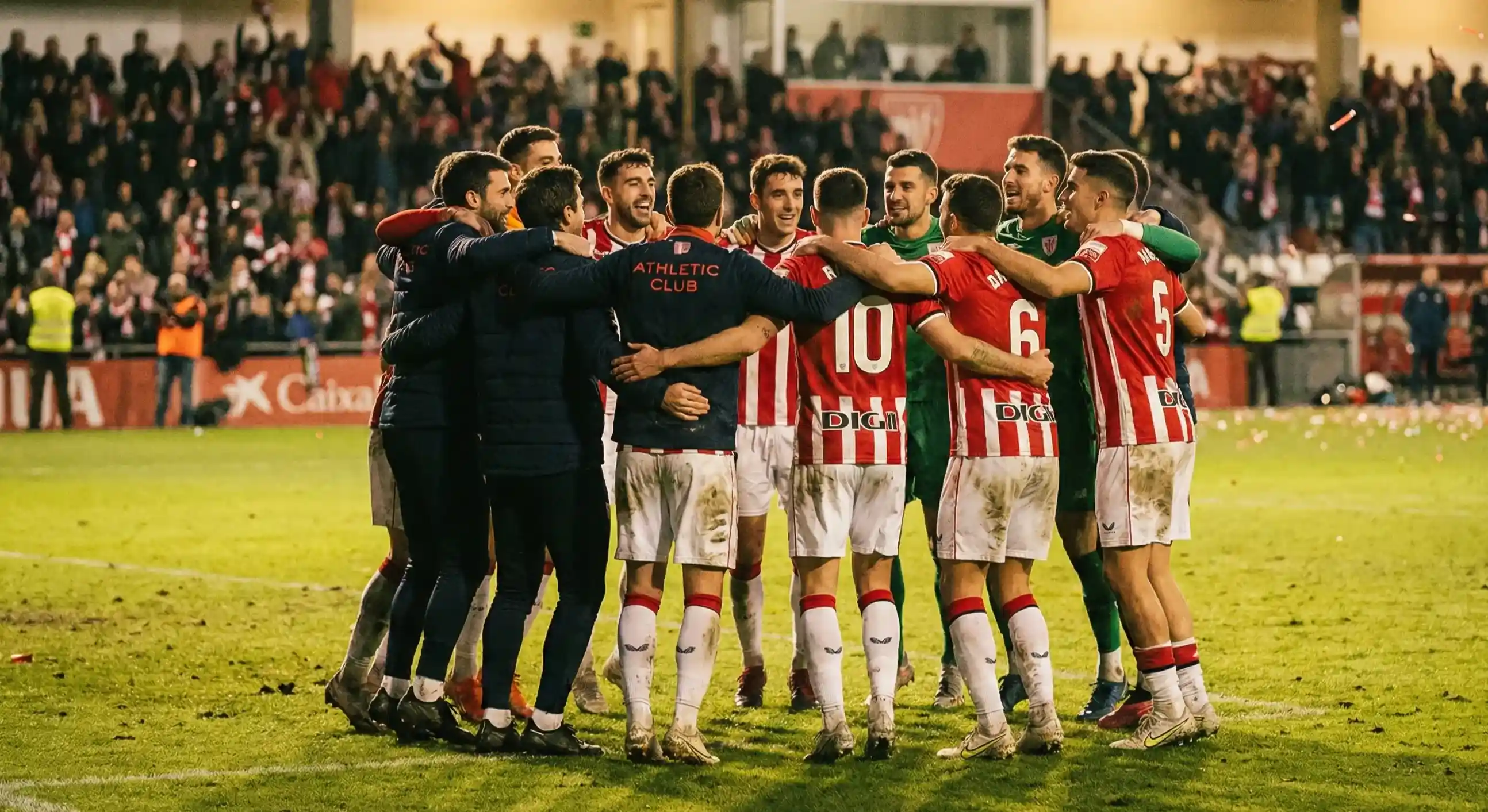 Football team celebrating together in a huddle on the pitch