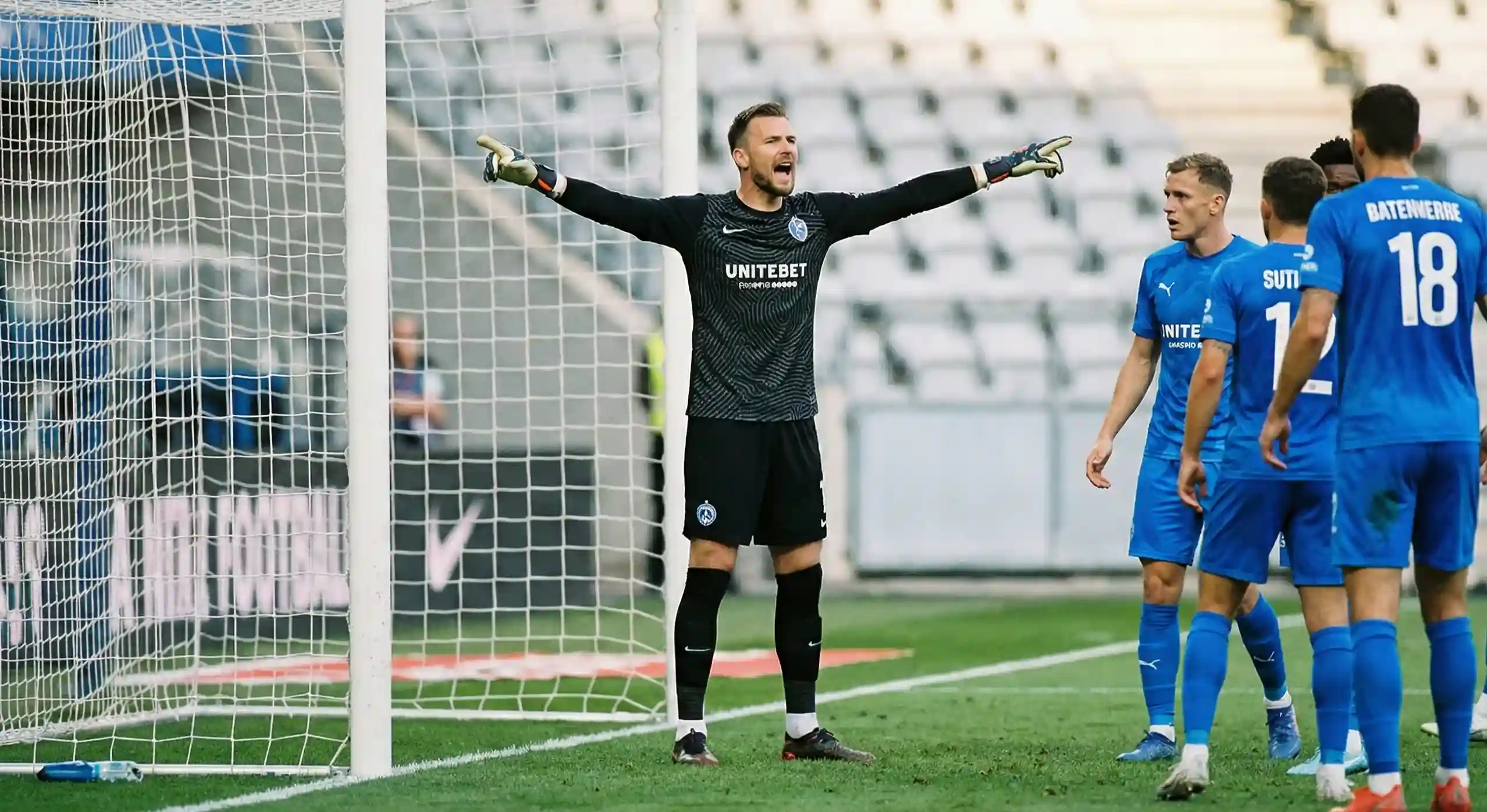Goalkeeper directing defenders and pointing during a match