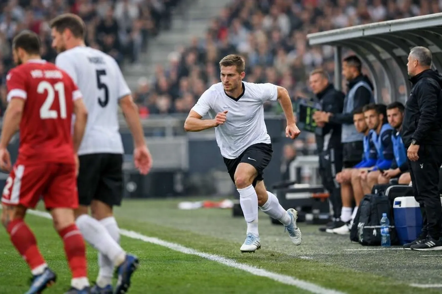 Football substitute player running onto the pitch during a match