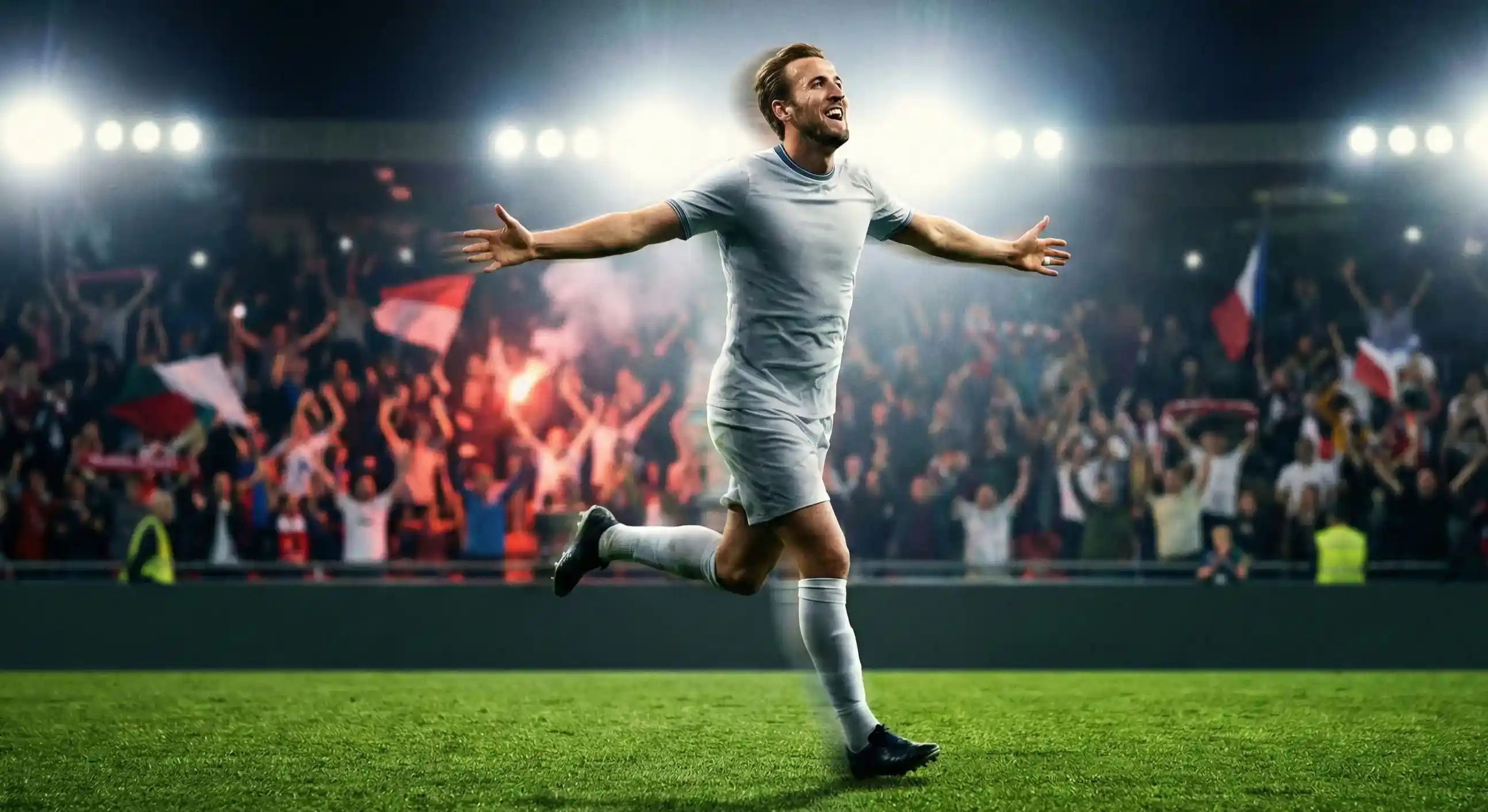 Football player running with arms outstretched celebrating after scoring a goal